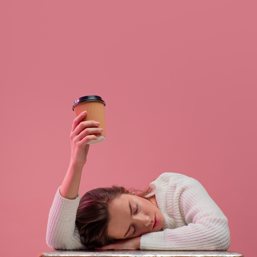 sleepy, exhausted woman holding coffee cup